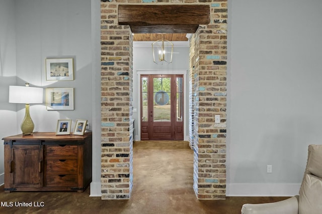 entryway featuring concrete flooring and a chandelier