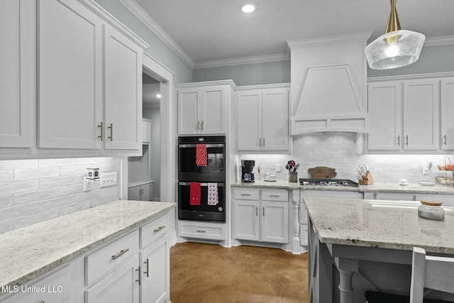 kitchen with hanging light fixtures, custom range hood, and white cabinets