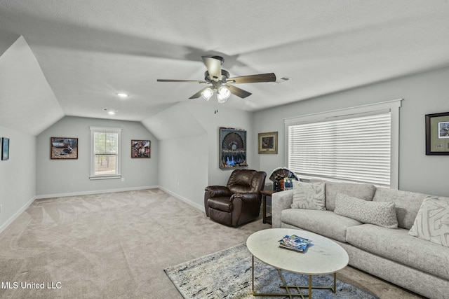 living room featuring vaulted ceiling, light colored carpet, a textured ceiling, and ceiling fan