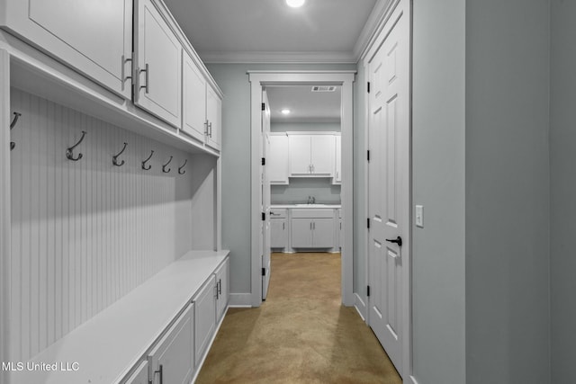 mudroom with crown molding and sink