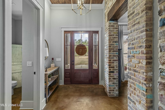 carpeted foyer featuring ornamental molding, brick wall, and an inviting chandelier