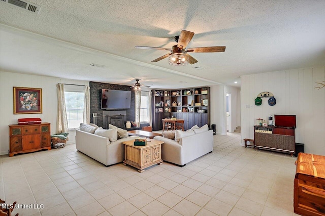 12661 Springridge Rd, Terry, MS 39170 - living room featuring healthy amount of natural light, a textured ceiling, a ceiling fan, and light tile patterned flooring