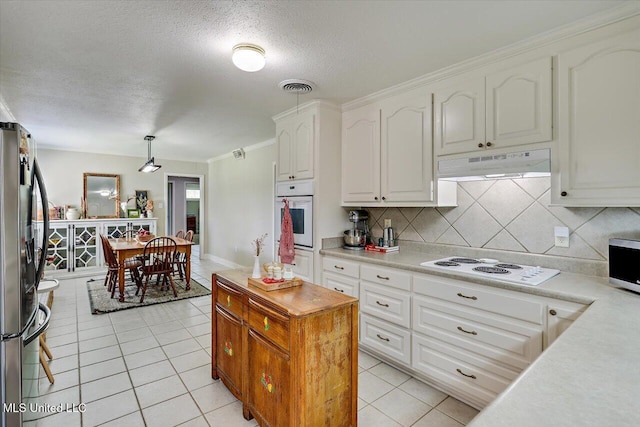 12661 Springridge Rd, Terry, MS 39170 - kitchen featuring under cabinet range hood, stainless steel appliances, light tile patterned floors, white cabinets, and light countertops