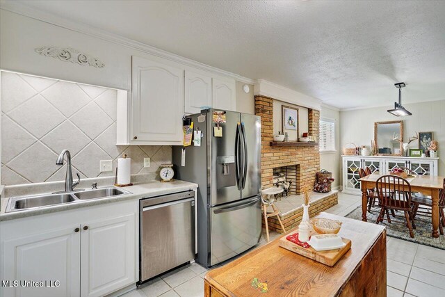 12661 Springridge Rd, Terry, MS 39170 - kitchen featuring stainless steel appliances, a sink, light tile patterned floors, a textured ceiling, and white cabinets