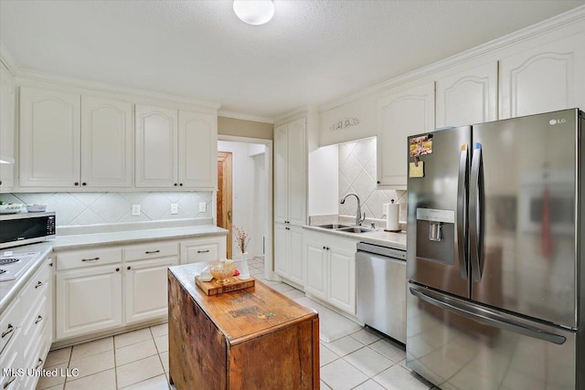 12661 Springridge Rd, Terry, MS 39170 - kitchen featuring stainless steel appliances, a sink, light tile patterned floors, tasteful backsplash, and crown molding