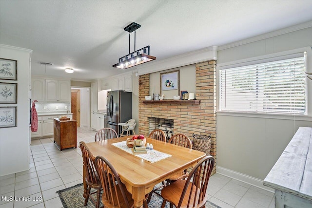 12661 Springridge Rd, Terry, MS 39170 - dining room with light tile patterned floors, a brick fireplace, baseboards, and a textured ceiling