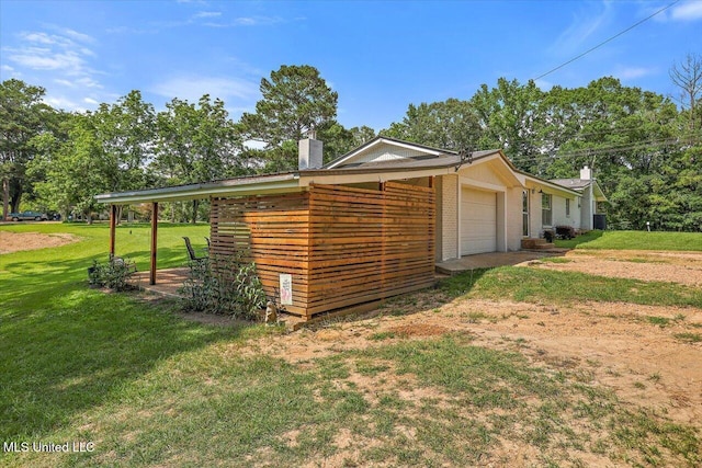 12661 Springridge Rd, Terry, MS 39170 - view of property exterior with a chimney, a garage, a yard, brick siding, and dirt driveway