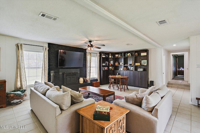 12661 Springridge Rd, Terry, MS 39170 - living room featuring tile patterned flooring, a ceiling fan, a textured ceiling, and plenty of natural light