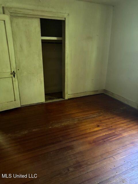 3411 25th Ave, Meridian, MS 39305 - unfurnished bedroom with baseboards, a closet, and dark wood-type flooring