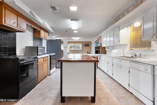 kitchen featuring a kitchen island, white cabinetry, a textured ceiling, and appliances with stainless steel finishes