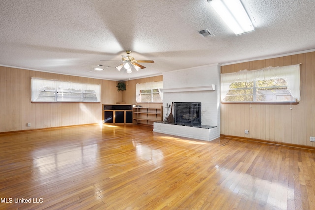 14071 Duckworth Rd, Gulfport, MS 39503 - unfurnished living room featuring ceiling fan, wood-type flooring, a brick fireplace, baseboards, and a textured ceiling