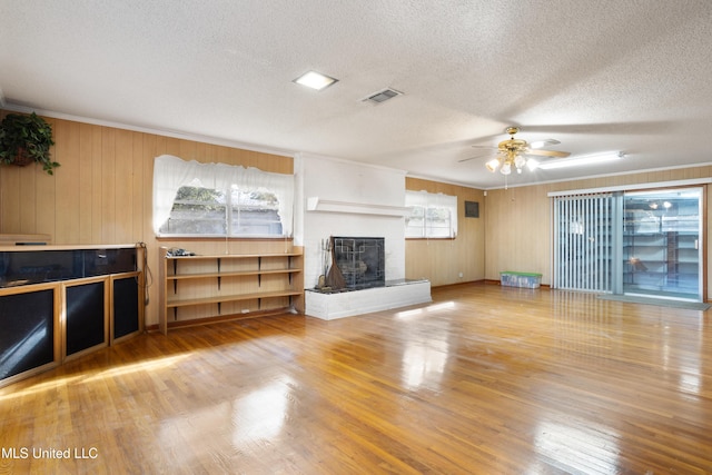 14071 Duckworth Rd, Gulfport, MS 39503 - unfurnished living room with crown molding, a fireplace, ceiling fan, a textured ceiling, and wood finished floors