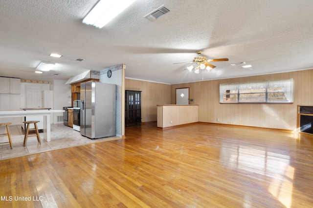 14071 Duckworth Rd, Gulfport, MS 39503 - unfurnished living room with light wood finished floors, baseboards, a textured ceiling, and a ceiling fan