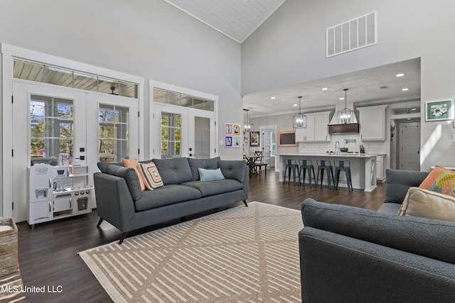 living area with french doors, high vaulted ceiling, dark wood-type flooring, and visible vents