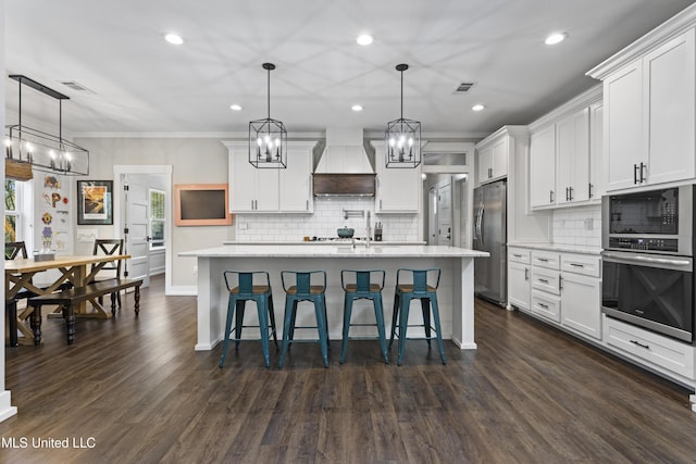 kitchen with visible vents, custom exhaust hood, appliances with stainless steel finishes, and an inviting chandelier