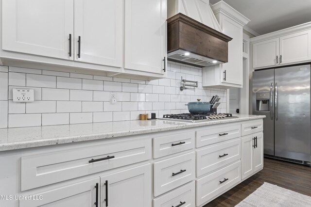 kitchen featuring white cabinets, custom exhaust hood, tasteful backsplash, dark wood-type flooring, and appliances with stainless steel finishes