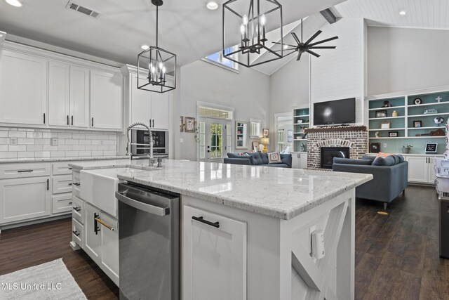 kitchen featuring open floor plan, a chandelier, an island with sink, visible vents, and dishwasher