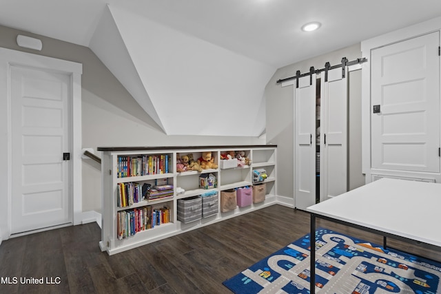 rec room with dark wood-style floors, lofted ceiling, and a barn door