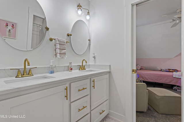 ensuite bathroom with ensuite bathroom, double vanity, a sink, and a ceiling fan