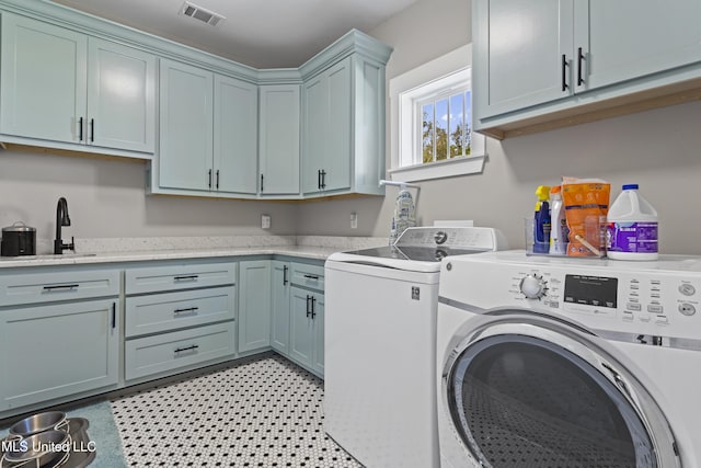 laundry area with separate washer and dryer, visible vents, cabinet space, and a sink