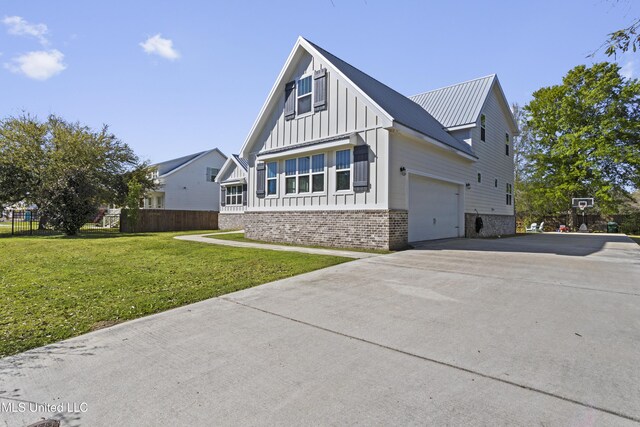 view of front of home with driveway, a front yard, fence, brick siding, and board and batten siding