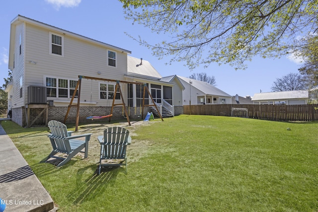 back of property with a lawn, a sunroom, stairs, and fence private yard