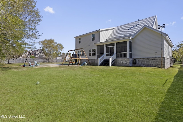 back of property with a playground, a sunroom, fence, and a lawn