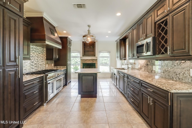 5029 Crescent Ridge Dr, Kiln, MS 39556 - kitchen with stainless steel appliances, recessed lighting, backsplash, dark brown cabinets, and light stone counters
