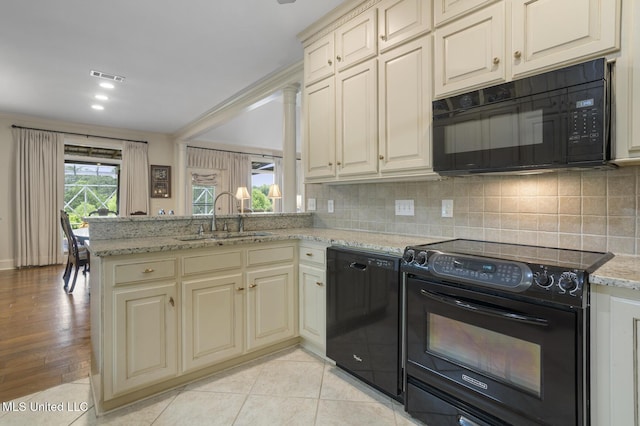 215 Azalea Ct, Brandon, MS 39047 - kitchen featuring black appliances, cream cabinetry, a sink, and decorative backsplash