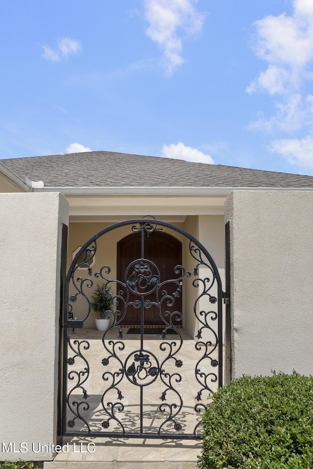215 Azalea Ct, Brandon, MS 39047 - exterior view of a gate, stucco siding, and roof with shingles