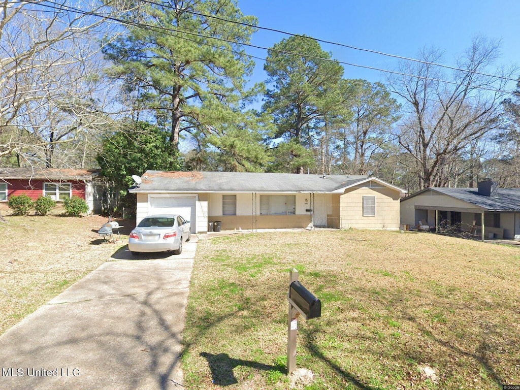 ranch-style house with concrete driveway, an attached garage, and a front lawn