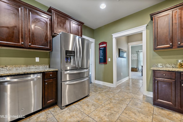 18225 Tulip Cv, Gulfport, MS 39503 - kitchen featuring stainless steel appliances, light stone counters, baseboards, and light tile patterned floors