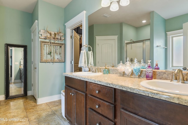 18225 Tulip Cv, Gulfport, MS 39503 - bathroom featuring a shower stall, double vanity, tile patterned floors, and baseboards