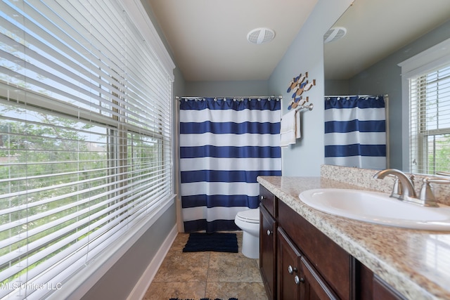 18225 Tulip Cv, Gulfport, MS 39503 - full bath featuring toilet, vanity, baseboards, curtained shower, and stone finish floors