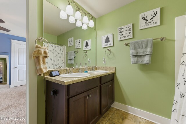 18225 Tulip Cv, Gulfport, MS 39503 - full bath featuring baseboards, double vanity, and ceiling fan