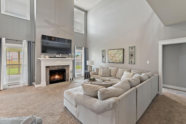 18225 Tulip Cv, Gulfport, MS 39503 - carpeted living area featuring a high ceiling, a stone fireplace, plenty of natural light, and baseboards