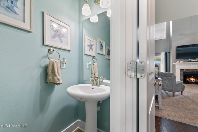 18225 Tulip Cv, Gulfport, MS 39503 - bathroom featuring a stone fireplace and wood finished floors