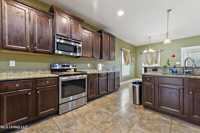 18225 Tulip Cv, Gulfport, MS 39503 - kitchen featuring appliances with stainless steel finishes, a sink, dark brown cabinetry, light tile patterned flooring, and a chandelier