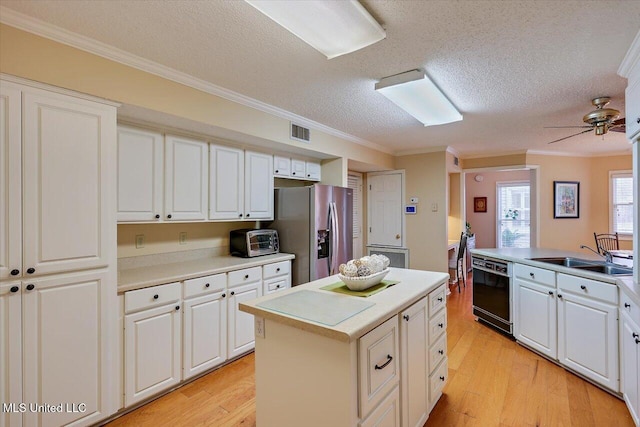 kitchen featuring stainless steel fridge, black dishwasher, sink, and white cabinets