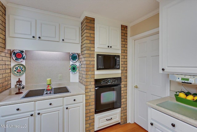 kitchen with white cabinetry, crown molding, and black appliances