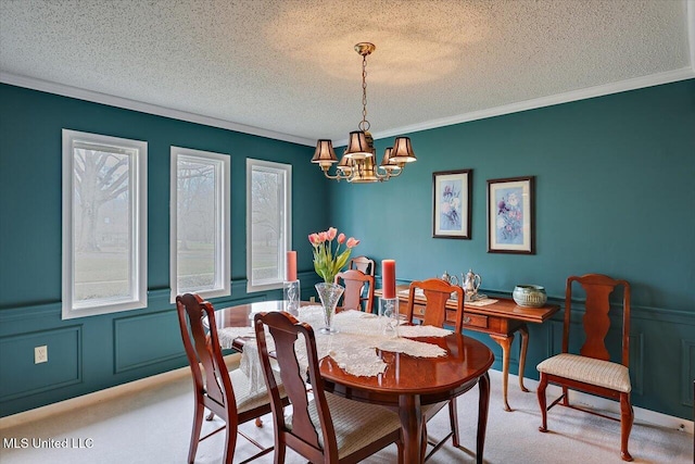 carpeted dining space with ornamental molding, a chandelier, and a textured ceiling