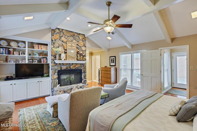 bedroom featuring a fireplace, light hardwood / wood-style floors, lofted ceiling with beams, and ceiling fan