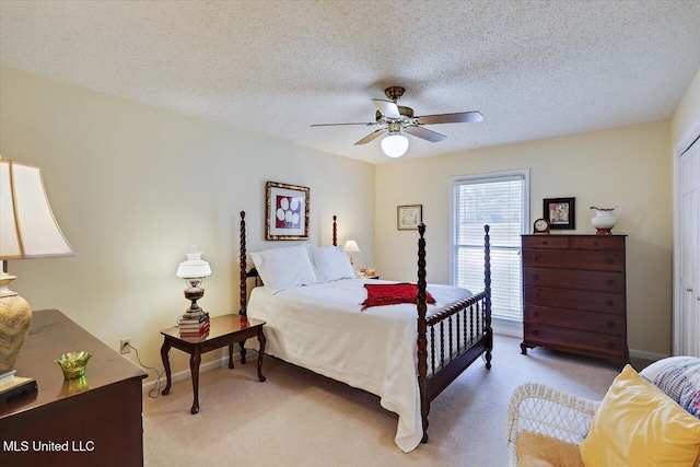 carpeted bedroom with ceiling fan and a textured ceiling