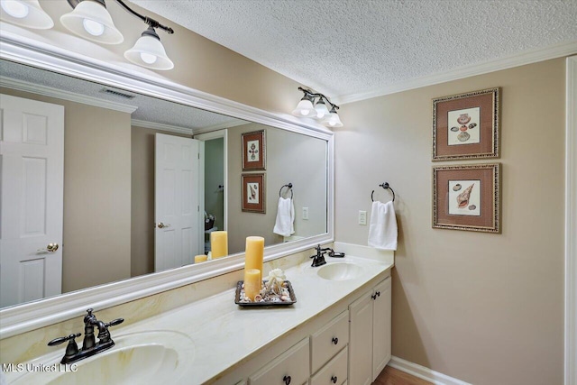 bathroom featuring ornamental molding, vanity, and a textured ceiling