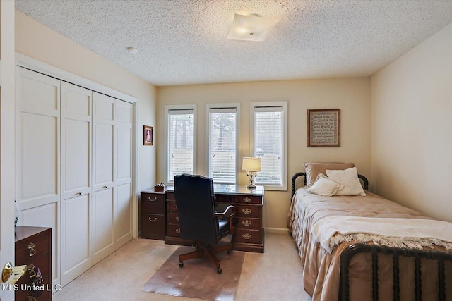 carpeted bedroom featuring a closet and a textured ceiling