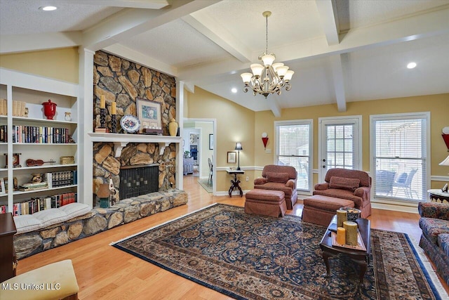 living room featuring hardwood / wood-style flooring, a fireplace, a textured ceiling, and vaulted ceiling with beams