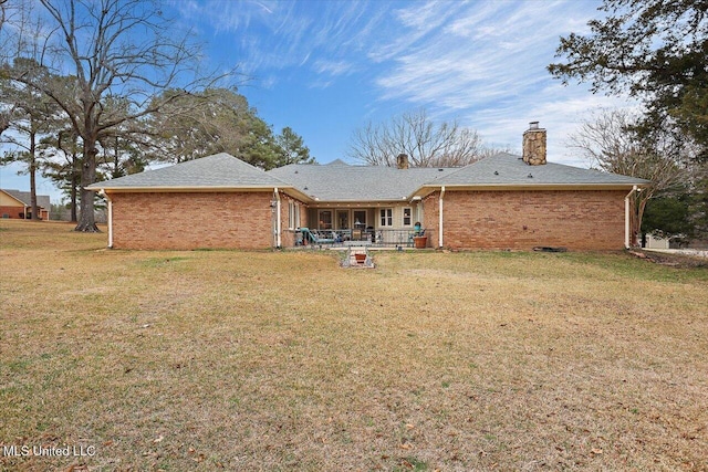 back of house featuring a lawn and a patio