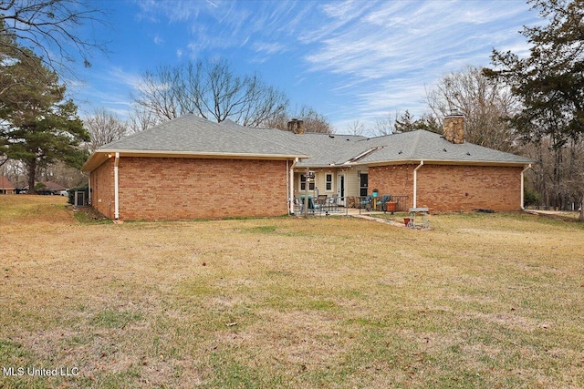 rear view of house with a patio area and a lawn