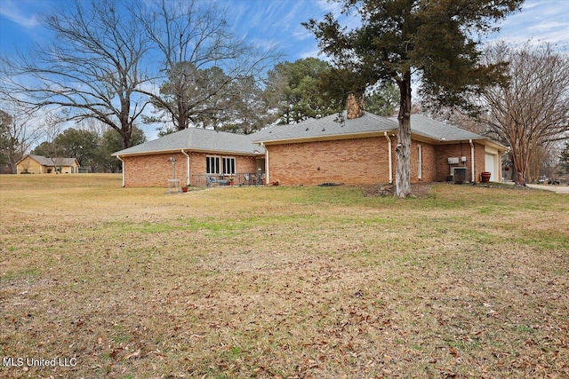 back of house featuring a garage and a lawn