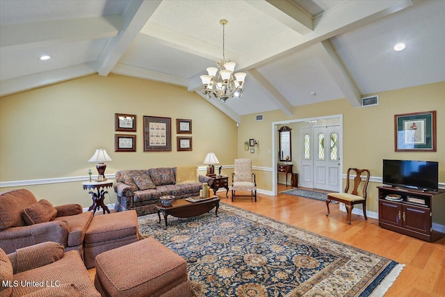 living room with lofted ceiling with beams, a notable chandelier, and light hardwood / wood-style flooring